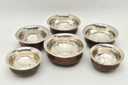 SIX ASSORTED 19TH CENTURY TIBETAN WOODEN BOWLS WITH WHITE METAL LININGS/MOUNTS, largest diameter