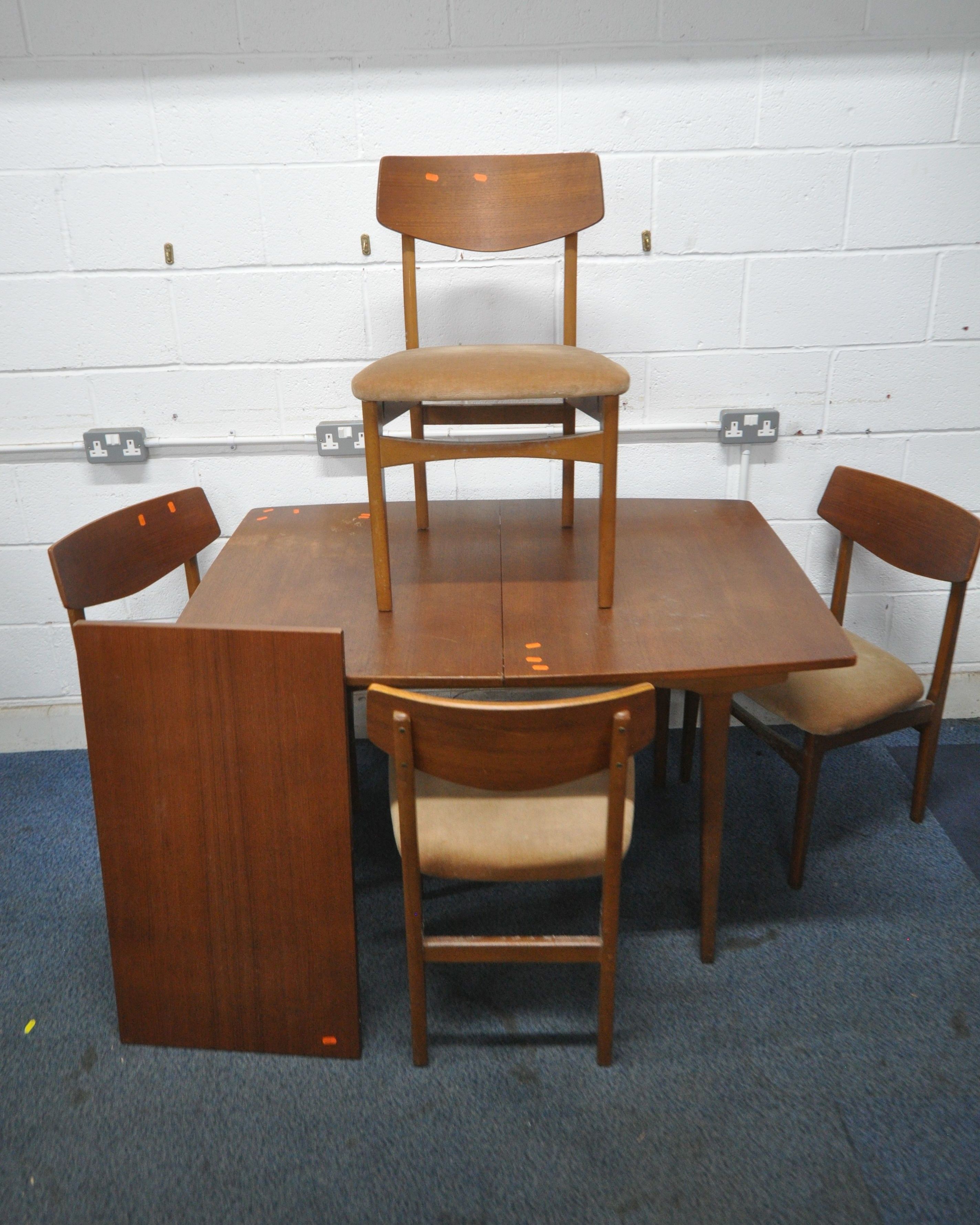 A MID CENTURY TEAK EXTENDING DINING TABLE, with one additional leaf, raised on tapered legs,