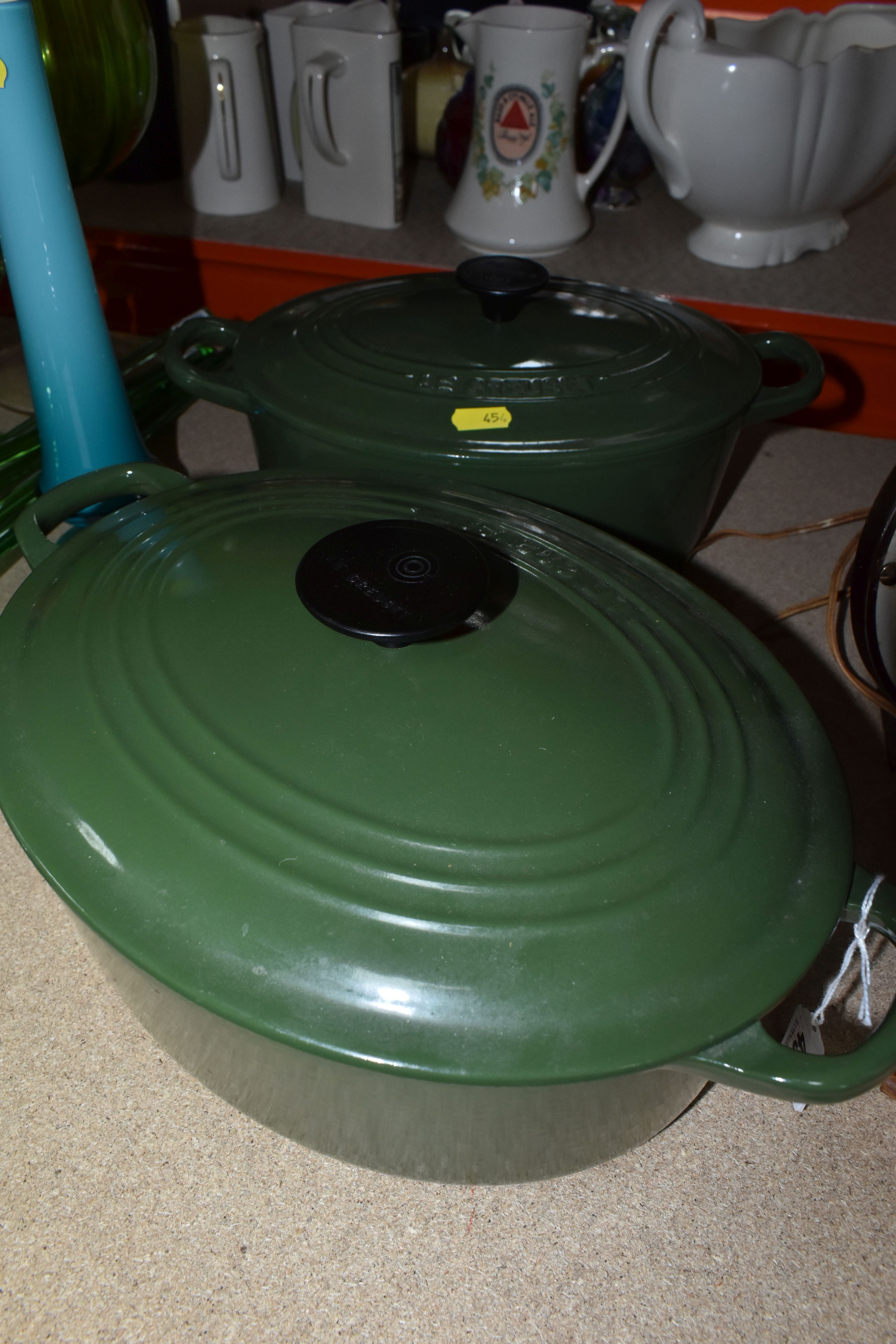 TWO GREEN LE CREUSET CASSEROLE DISHES to include a 27cm lidded casserole dish and matching 25cm dish