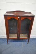 AN EDWARDIAN MAHOGANY BOOKCASE, with double glazed doors, raised on square tapered legs, with