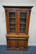 A VICTORIAN MAHOGANY BOOKCASE, the double glazed doors enclosing three shelves, atop a base with a