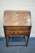 A 20TH CENTURY OAK BUREAU, the fall front door enclosing a fitted interior, above two drawers,