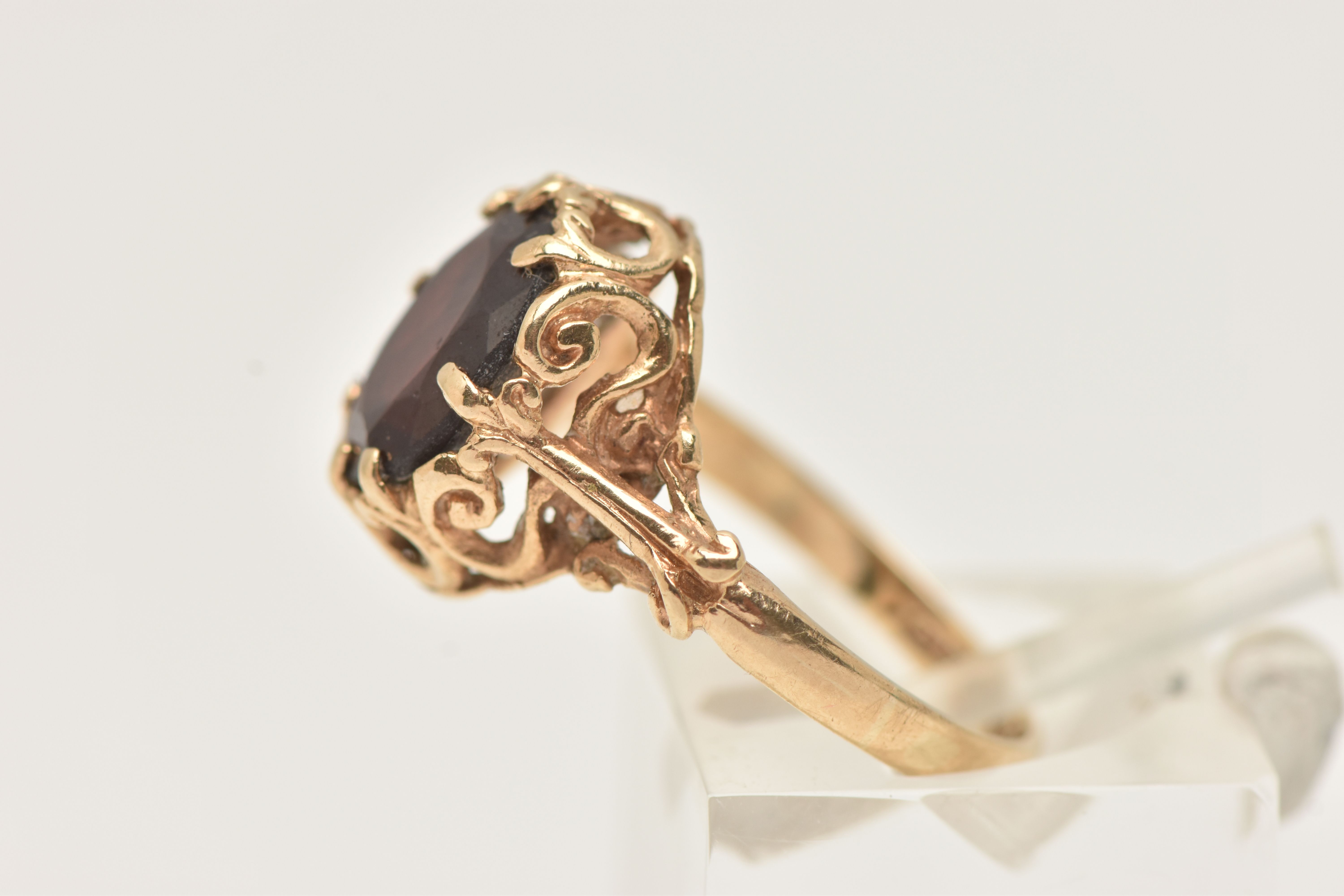 A 9CT GOLD GARNET RING, the oval garnet in an eight claw setting, to the scrolling gallery and - Image 2 of 4