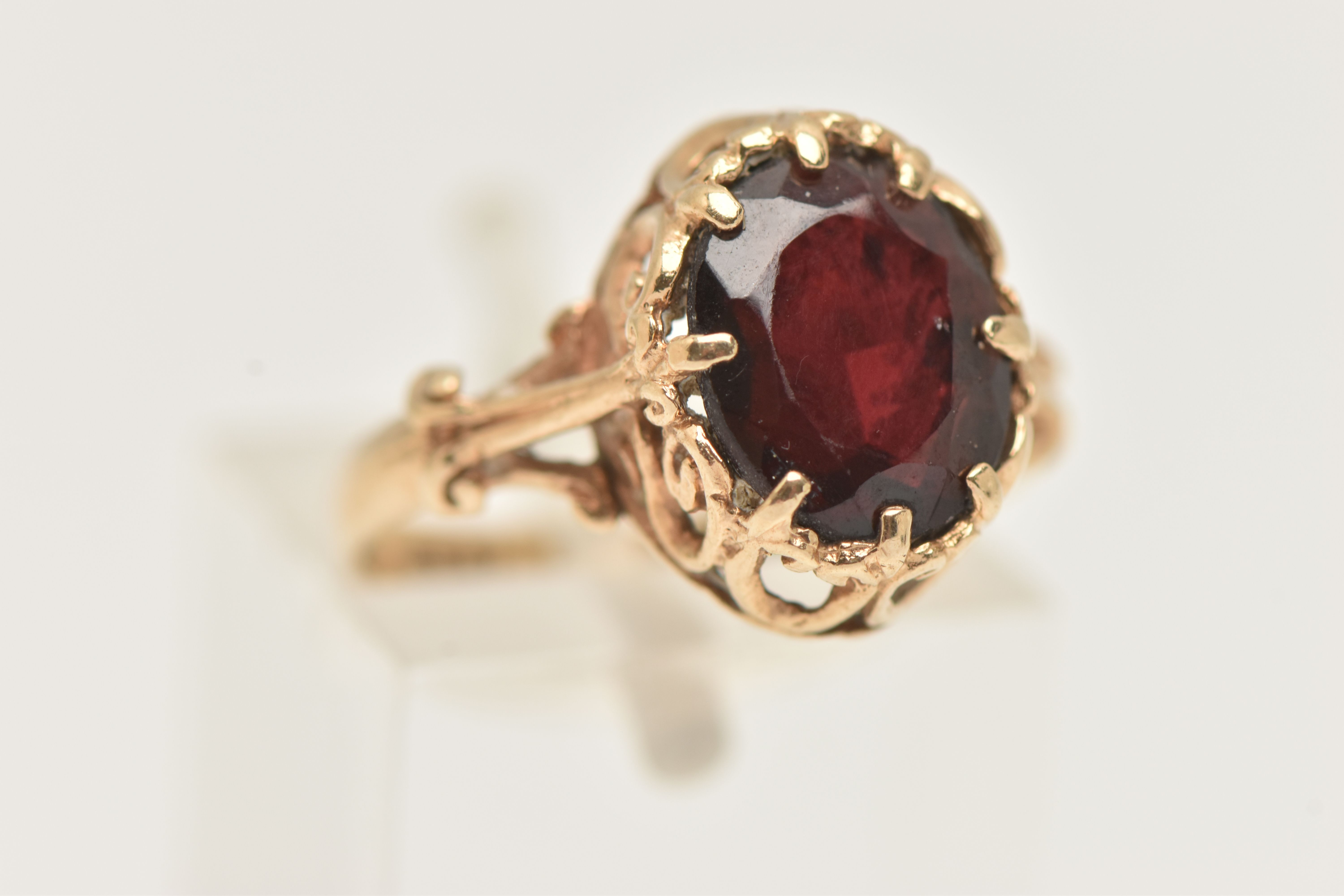 A 9CT GOLD GARNET RING, the oval garnet in an eight claw setting, to the scrolling gallery and - Image 4 of 4