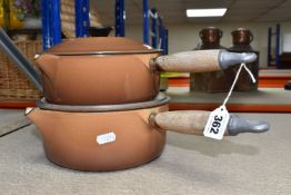 TWO LE CREUSET CAST IRON SAUCEPANS, in brown enamel, with pouring lips and wooden handles, diameters