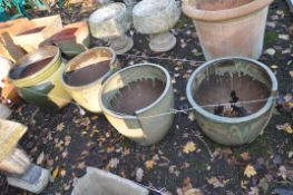 A SELECTION OF GREEN GLAZED PLANT POTS, including a set of three 46cm in diameter with an