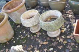 A PAIR OF WEATHERED COMPOSITE GARDEN URNS ON STAND, with foliate detail to bowls and bases, height