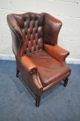 AN OXBLOOD BUTTONED LEATHER CHESTERFIELD WINGBACK ARMCHAIR, with scrolled armrests, width 87cm x