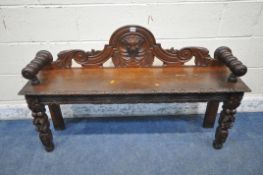 AN EARLY 20TH CENTURY OAK GOTHIC HALL BENCH, with turned armrests, scrolled backrest, with a central