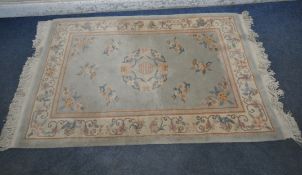 A CHINESE RECTANGULAR WOOLLEN RUG, with central medallion, repeating patterns, surrounded by a