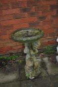 A WEATHERED COMPOSITE WATER FEATURE, in the form of a cherub holding a bowl aloft, with pipe through