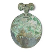 A Chinese archaic silvered bronze hand mirror Han dynasty With stylised ram head handle, fitted...