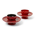 Two Japanese red lacquer cup stands 20th century Of typical form, lacquered red with black stre...