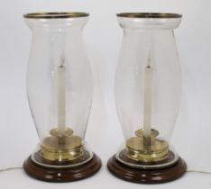 A pair of storm lanterns, 20th century, wired for electricity, brass and turned wood base, the gl...