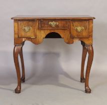 A George II feather banded walnut lowboy, second quarter 18th century, three drawers, on cabriole...