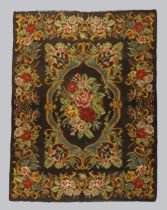 An English needlework tapestry, first quarter 20th century, floral design, on a dark brown ground...