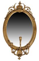 A Victorian gilt wood and gesso girandole, c.1860, the moulded beaded oval frame with carved shel...