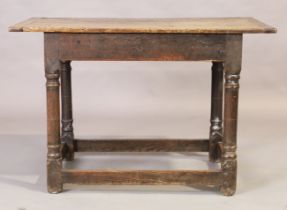 An English oak plank top side table, 18th century, on turned legs to block feet, joined by stretc...