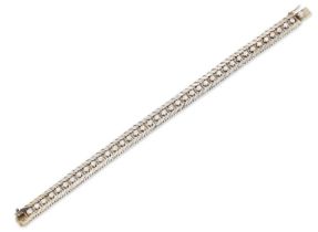 A diamond line bracelet, designed as a series of claw set brilliant cut diamonds to polished feat...