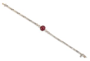 An early 20th century 18ct gold ruby and diamond bracelet, an oval cabochon ruby with a pair of o...