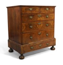 A Queen Anne feather banded walnut chest on stand, first quarter 18th century, with two short and...