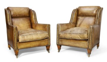 A pair of Edwardian mahogany and tan leather armchairs, first quarter 20th century, with stud bou...