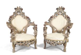 A pair of Italian carved wood armchairs, second quarter 20th century, the frames carved as entwin...