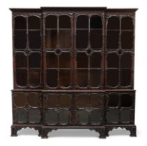 An English carved mahogany breakfront bookcase, in the manner of Thomas Chippendale, 19th century...