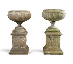 A pair of reconstituted stone urns, 20th century, on square-section plinth bases, 102cm high over...