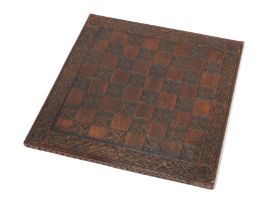 A late Victorian carved oak chessboard, late 19th century, the border and black squares carved wi...