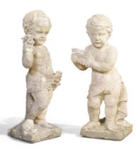 A pair of stone allegorical putti, late 19th century, one modelled holding roses, the other a pan...