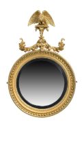 A Regency giltwood convex mirror, first quarter 19th century, the carved eagle crest perched upon...