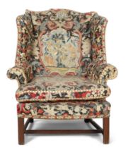 A George III mahogany wingback armchair, third quarter 18th century, with period tapestry upholst...