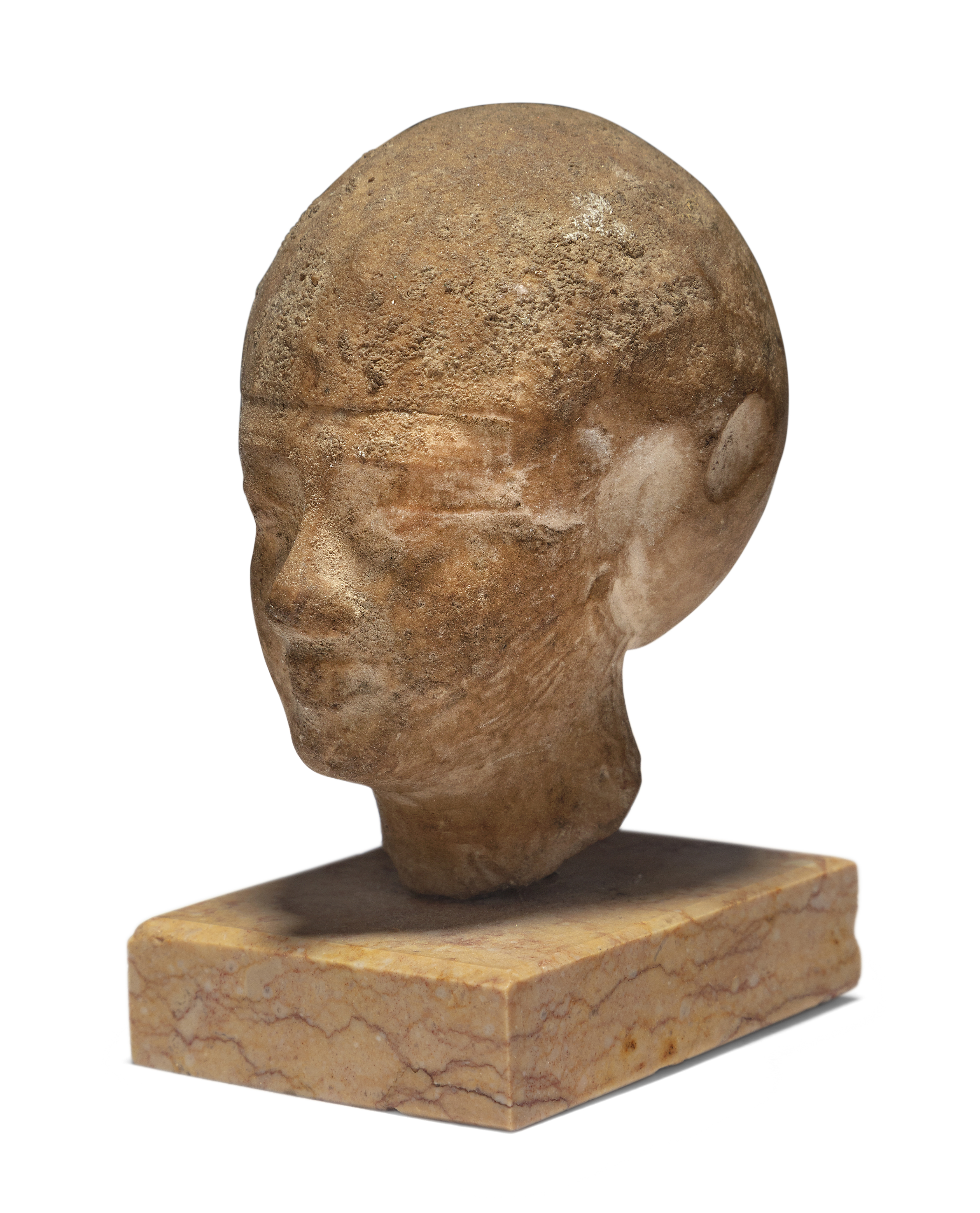 An Egyptian stone head of a male wearing close-fitting cap, possibly Late Period, likely modell...