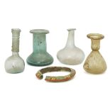 Four small Roman glass vessels and a bangle circa 2nd-4th century AD. Including a pale blue sph...
