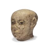 An Egyptian limestone male head with black painted pupils, probably Middle Kingdom, with traces...