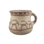 A Western Asiatic pottery handled cup, the deep bowl with rounded base and flared rim, the exter...