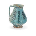 A Kashan turquoise glazed footed pottery jug,   Kashan, central Iran, 12th century, Pyriform, t...