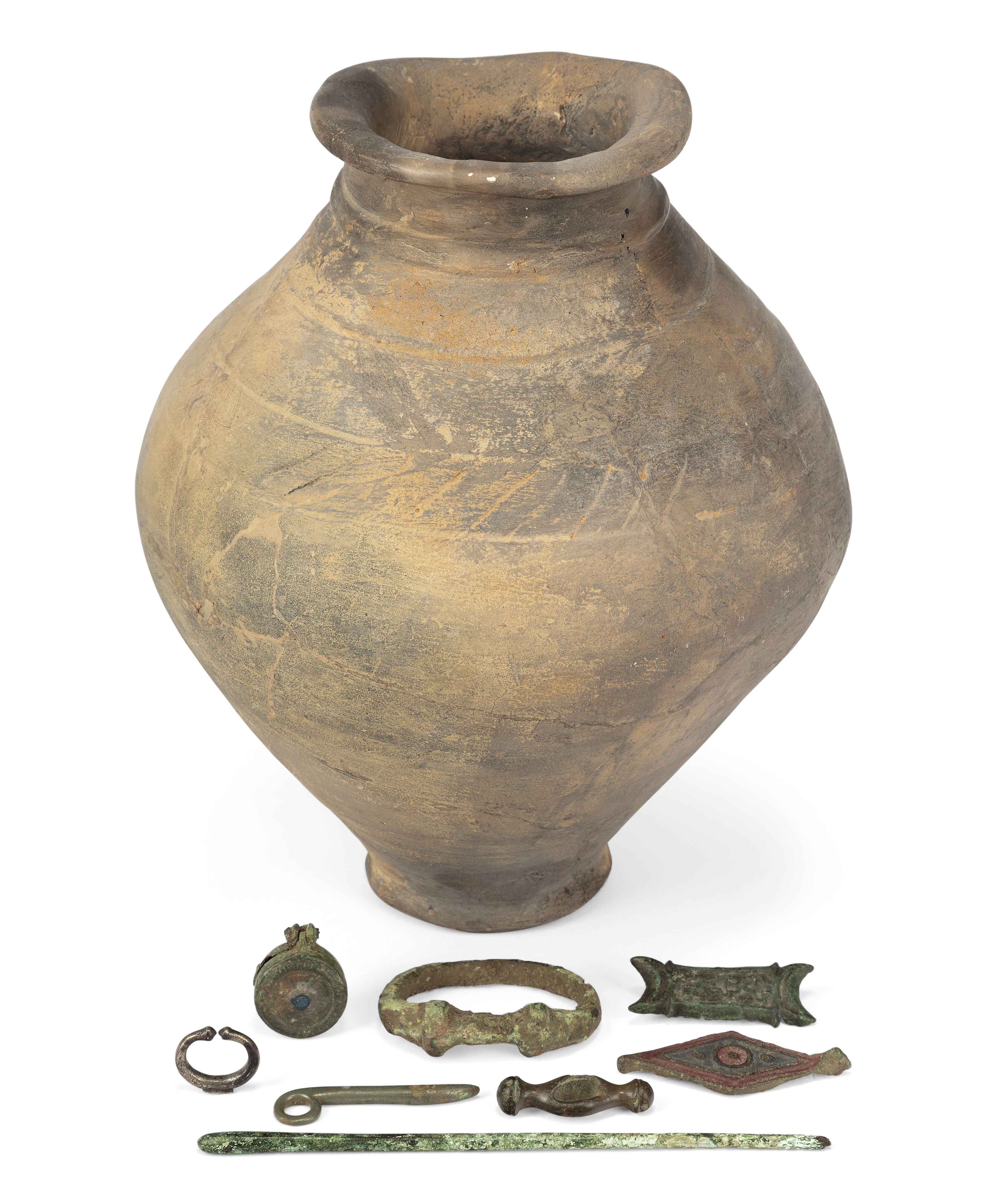 A restored La Tène III grey ware pottery urn, eight bronze and silver Celtic and Roman artefacts ...