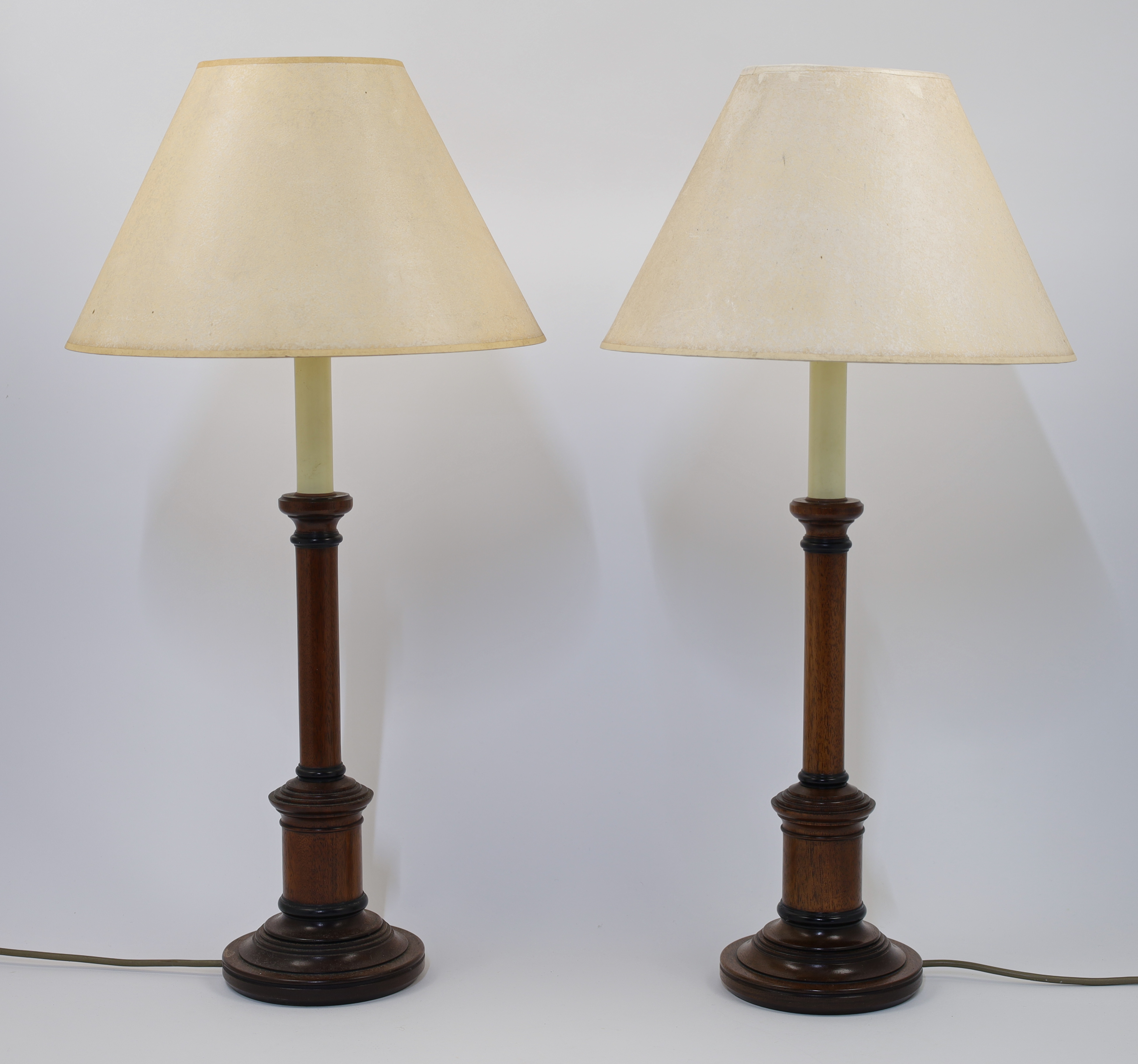 A pair of turned wood table lamps, 20th century, of columnar form on stepped circular bases, with...