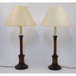 A pair of turned wood table lamps, 20th century, of columnar form on stepped circular bases, with...