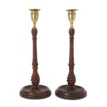 A pair of George III style turned mahogany candlesticks, 20th century, the brass sconces above fl...