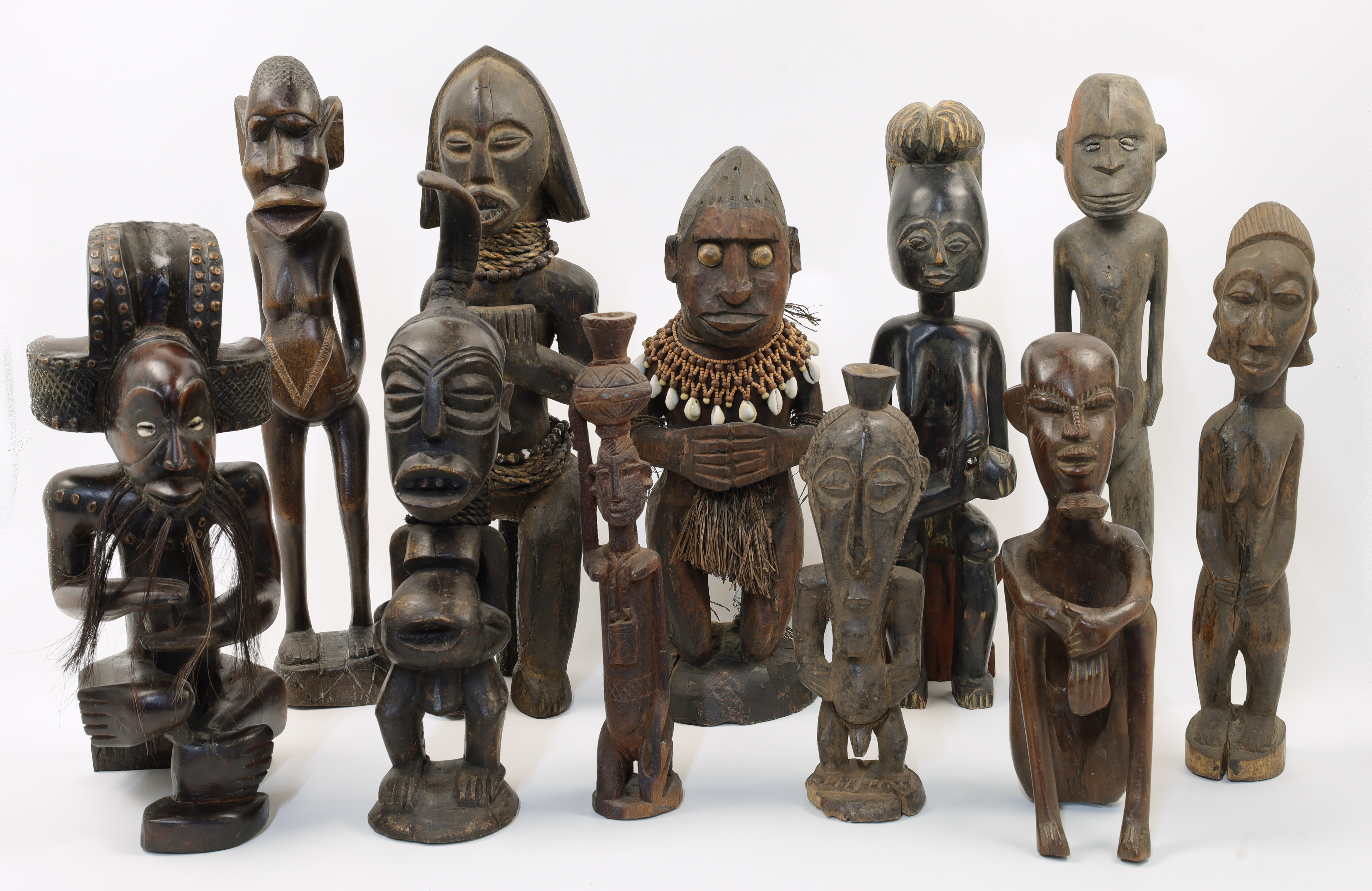 A collection of eleven tribal carved hardwood figures, 20th century, comprising a Fang style figu...