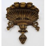 A carved and gilded wood wall bracket, 20th century, with leafy frieze above a shell flanked with...