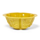A Chinese yellow 'Peking' glass foliate bowl, 20th century, each face carved with magnolias, 18cm...