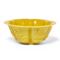 A Chinese yellow 'Peking' glass foliate bowl, 20th century, each face carved with magnolias, 18cm...