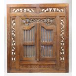 An Indonesian carved teak window shutter converted to a concealed mirror, 20th century, the hinge...