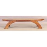 A tribal zoomorphic teak low table, 20th century, the top inset with caned section, on curved leg...