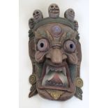 A large Tibetan Mahakala type carved and painted hardwood mask, 20th century, depicting a dharmap...