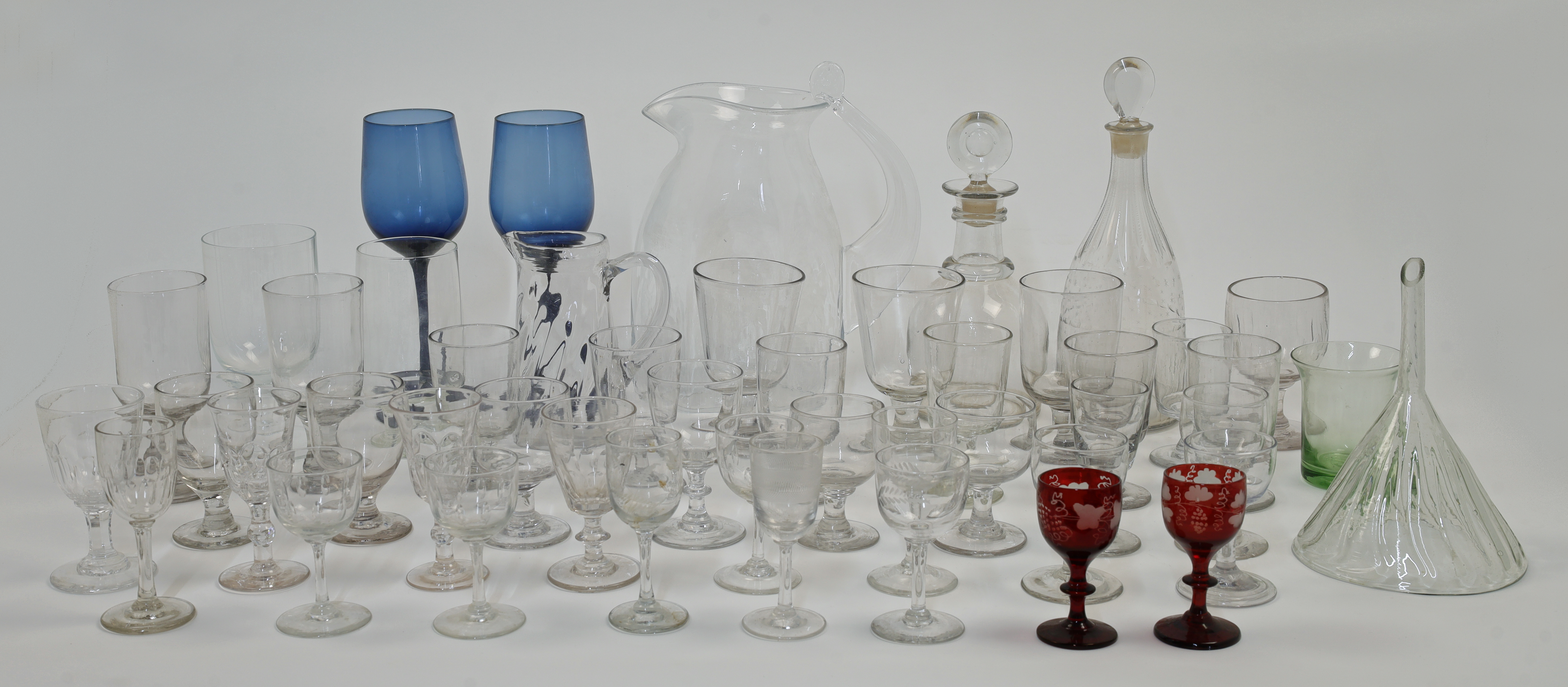 A quantity of glassware, 19th - 20th centuries, comprising: a collection of clear and coloured dr...